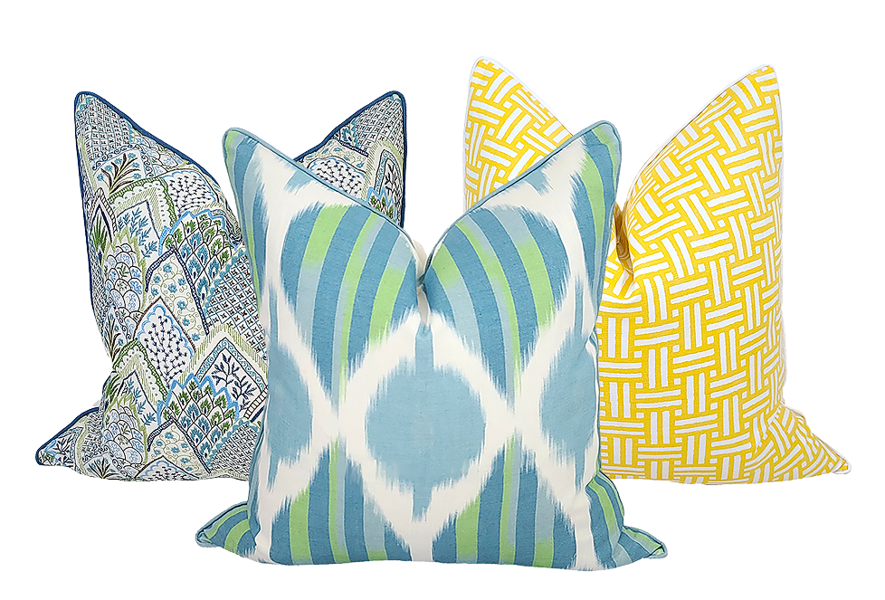 Three pillows with various patterns in yellows, blues, and greens